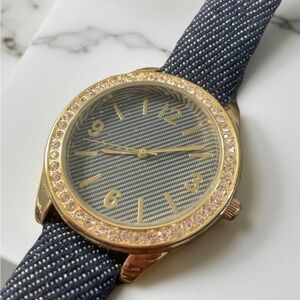 Women’s wristwatch features a stunning gold & blue jean strap. Watch runs well!
